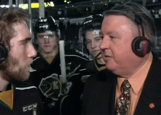 a man wearing headphones talks to a hockey player wearing a jersey that says ccm