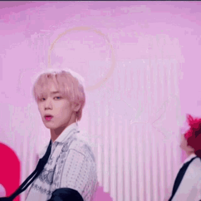 a man in a striped shirt is dancing in a pink room .