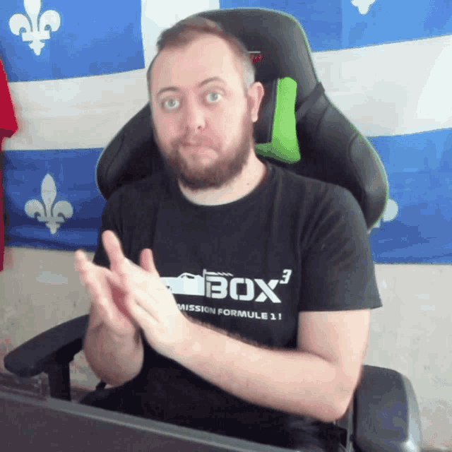 a man wearing a black shirt that says box3 is clapping his hands