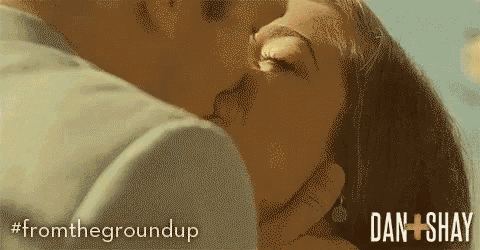 a close up of a man and woman kissing with the words from the groundup in the corner