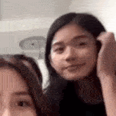 a couple of girls are standing next to each other and smiling .
