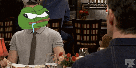 a man sitting at a table with a green frog on his head and a fx logo on the bottom right