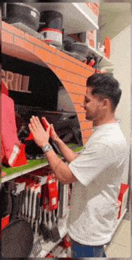 a man in a white shirt is standing in front of a shelf with a sign that says grill
