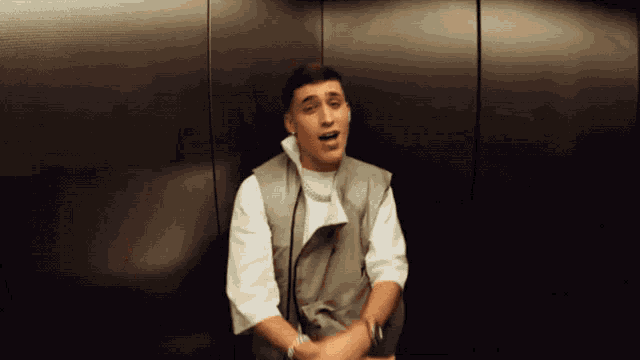 a man is sitting in an elevator and looking at the camera