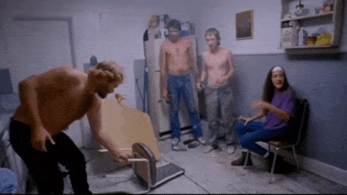 a group of people are gathered in a room and one of them is shirtless