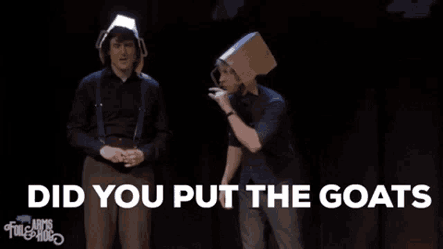 two men on a stage with a cardboard box on their head and the words did you put the goats above them .