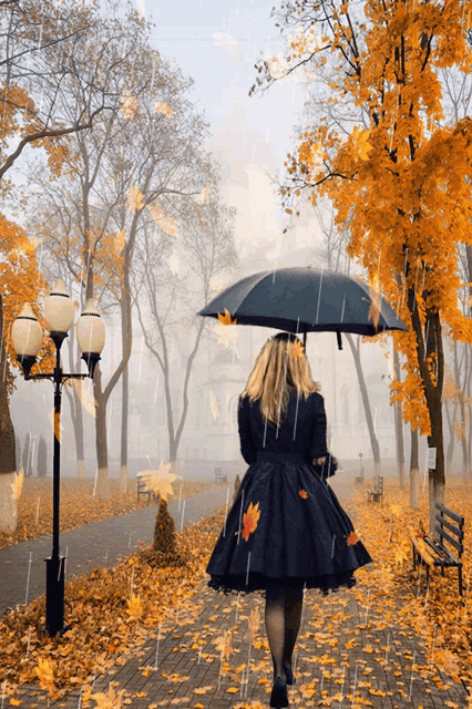 a woman in a black dress is walking in the rain holding an umbrella
