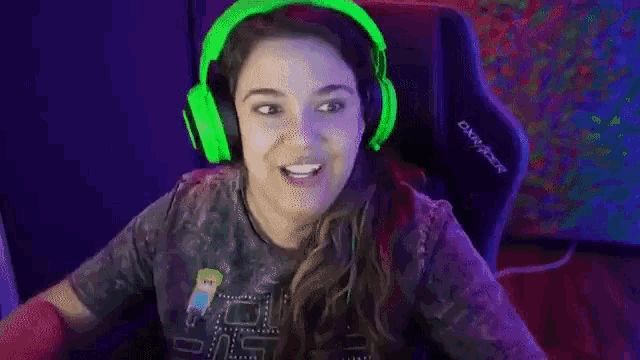 a woman wearing green headphones is sitting in a gaming chair and dancing .