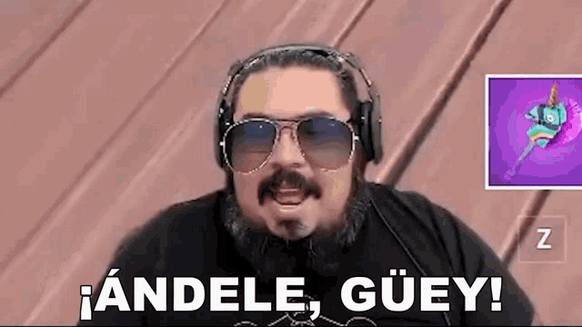 a man with a beard and sunglasses is wearing headphones and a black shirt .