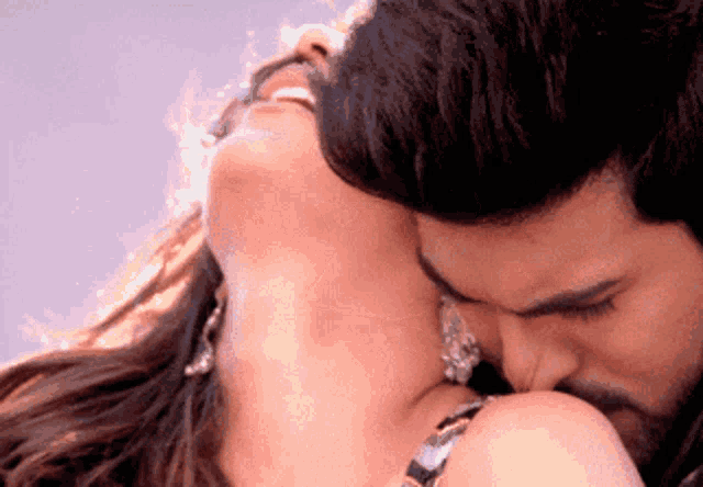 a man kissing a woman 's neck with a beard