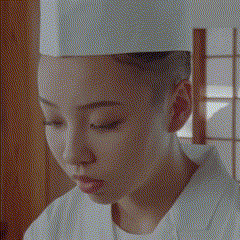 a close up of a woman wearing a chef 's hat and white shirt .