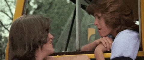 a man and a woman are looking into each other 's eyes while sitting in a bus