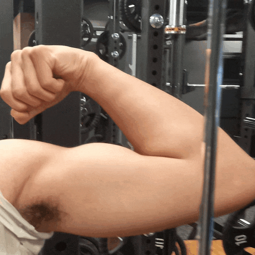 a man flexes his arm in front of a rack that says 10 on it