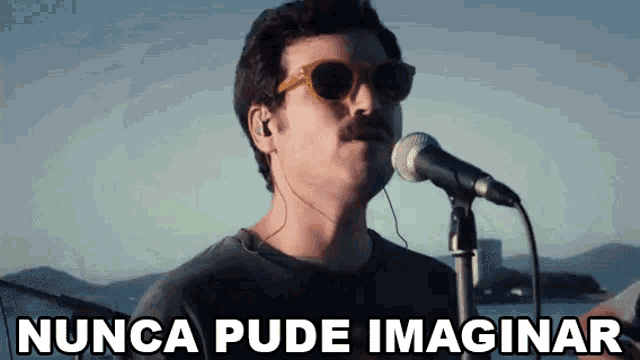 a man singing into a microphone with the words nunca pude imaginar