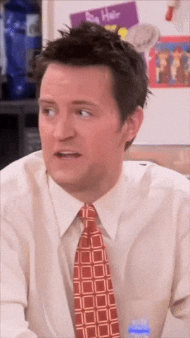a man wearing a tie and a white shirt looks surprised