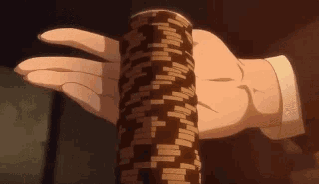 a man in a suit is holding a stack of poker chips in his hand .
