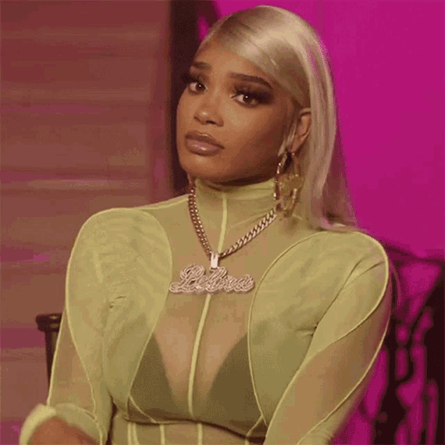 a woman wearing a neon green top and a necklace with the name princess on it