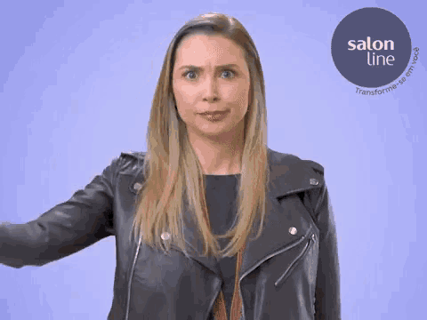 a woman in a leather jacket is making a funny face in front of a salon line logo