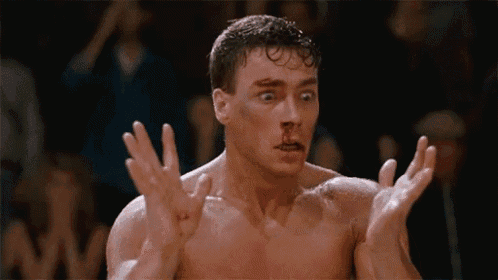 a man with blood on his face is making a funny face with his hands outstretched .