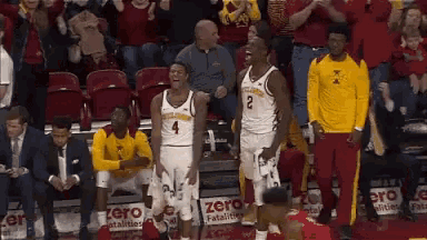 a couple of basketball players standing next to each other on a court