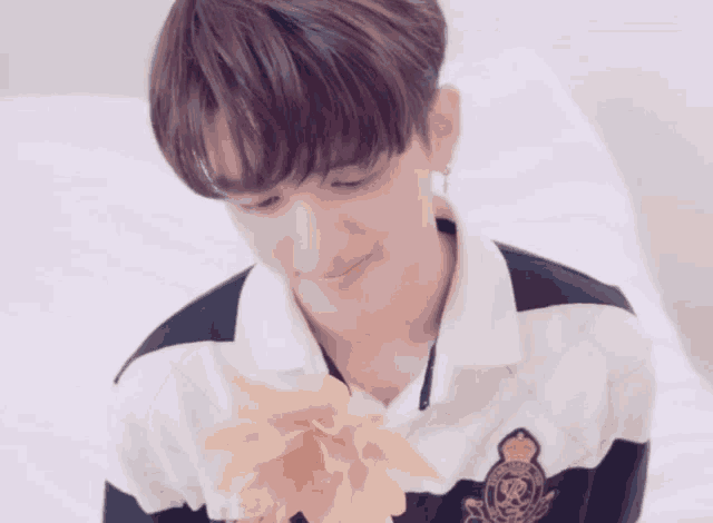 a young man in a black and white shirt holds a flower