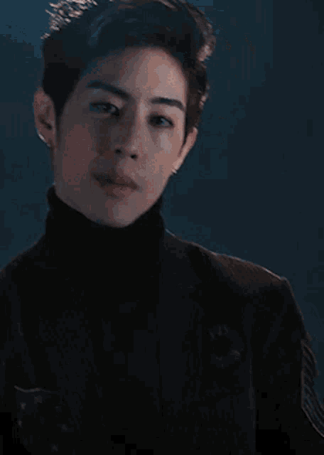 a close up of a man wearing a black turtleneck sweater