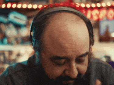 a bald man with a beard wearing headphones and a headband that says ' isa '