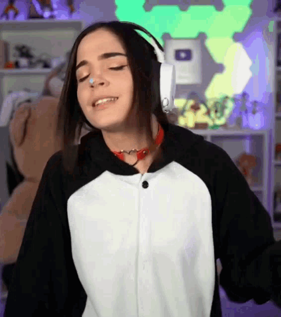 a girl wearing headphones and a penguin costume is dancing