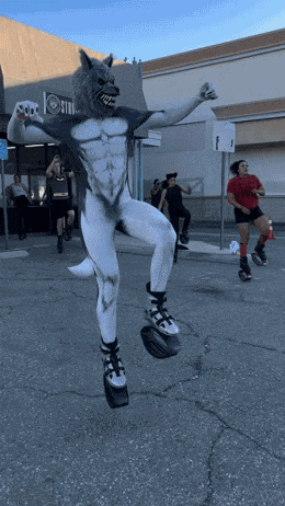 a person in a werewolf costume is jumping in the air in front of a store