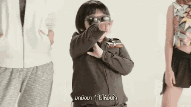 a young boy is wearing sunglasses and making a funny face .