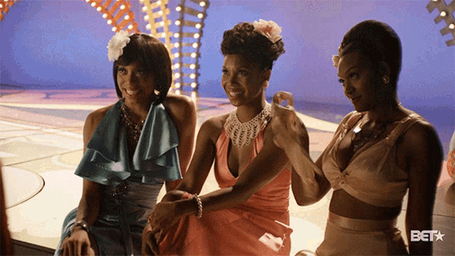 three women are standing next to each other with the bet logo on the bottom right