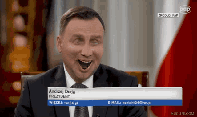 a man in a suit and tie is laughing with the name andrzej duda at the top