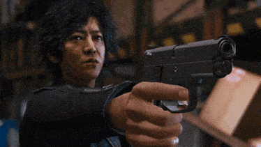 a man is pointing a gun at the camera and it says smith & wesson on it