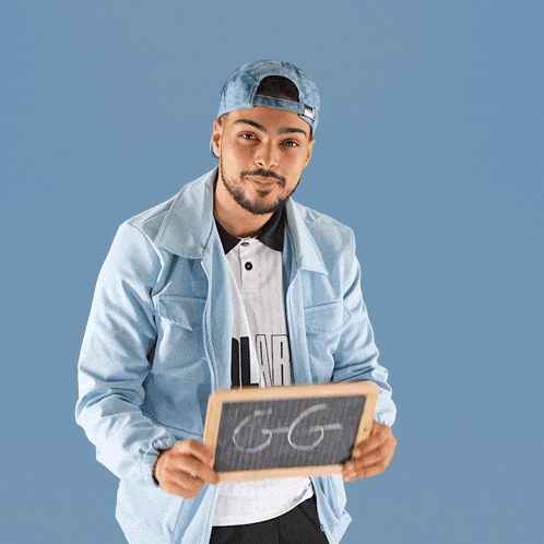a man in a blue jacket is holding a chalkboard with the word gg written on it