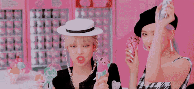 two women are holding ice cream cones in a pink room .