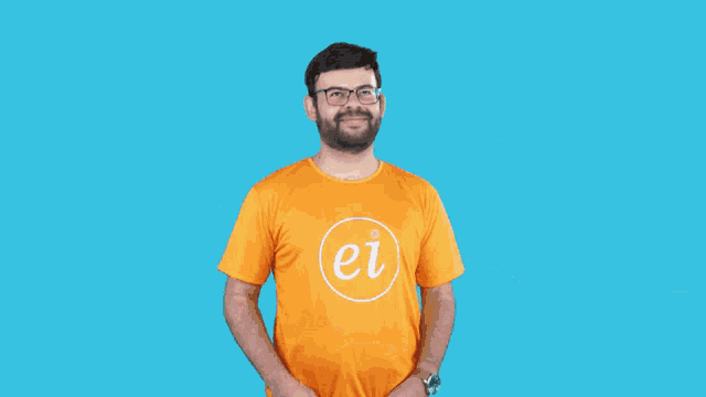 a man wearing glasses and an orange shirt is looking up in front of the letter f