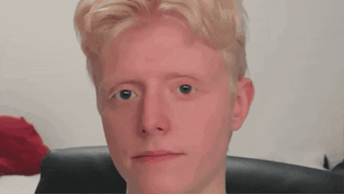 a close up of a young man 's face with a serious expression