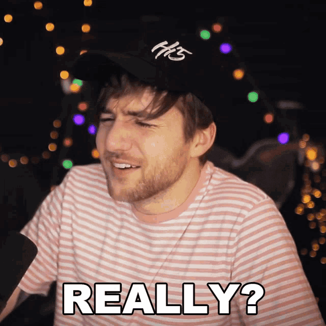 a man wearing a hat and a pink striped shirt says " really "