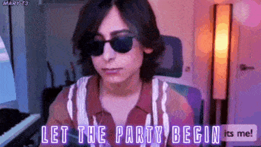 a man wearing sunglasses is sitting in front of a keyboard and says let the party begin .