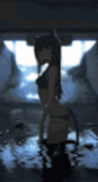 a blurred image of a girl in a bikini standing in a dark room .