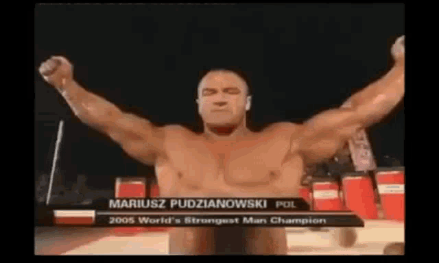 a man without a shirt is standing in front of a sign that says mariusz pudniakowski pol