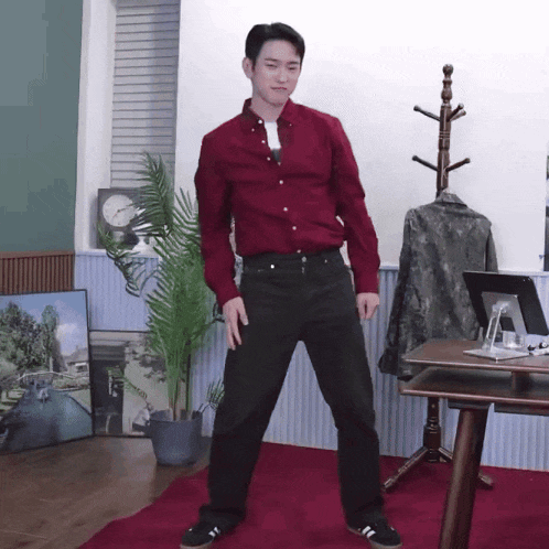 a man in a red shirt and black pants is dancing