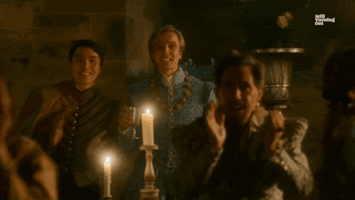 a group of people standing in front of a candle with the words kiss kiss kiss