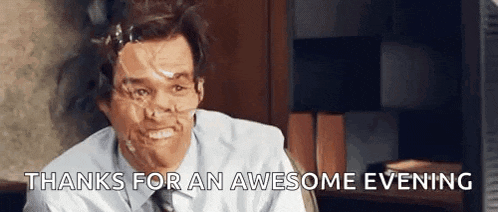 a man with duct tape on his face is sitting at a desk and smiling .