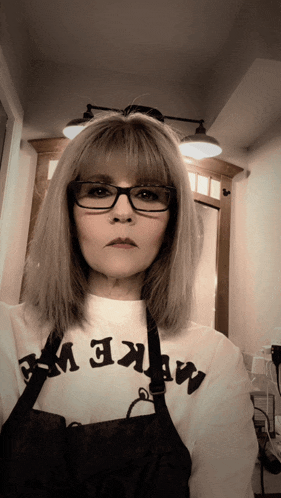 a woman wearing glasses and a shirt that says make up