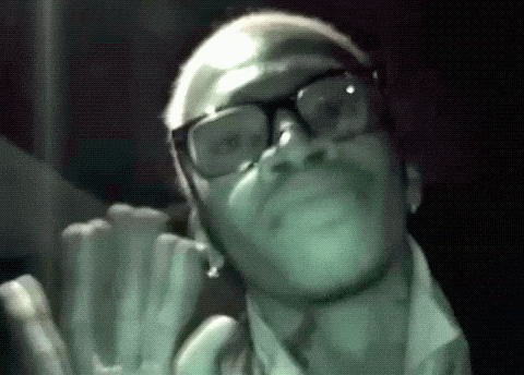 a man with glasses and a beard is looking up at something