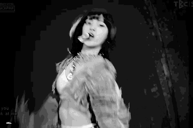 a black and white photo of a woman dancing on a stage with her tongue out .