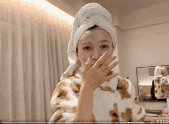 a woman with a towel wrapped around her head has a mask on her face and the word prisk is on the bottom