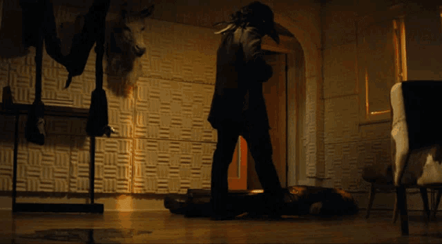 a man in a black mask is standing in a dark room
