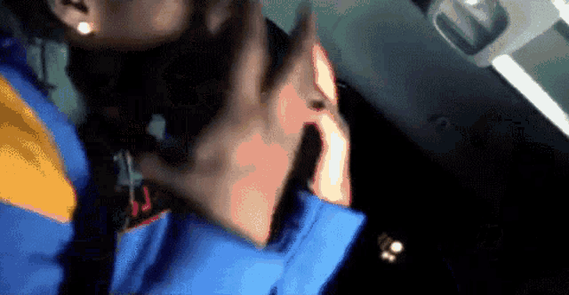 a person wearing a blue and orange jacket talking on a cell phone
